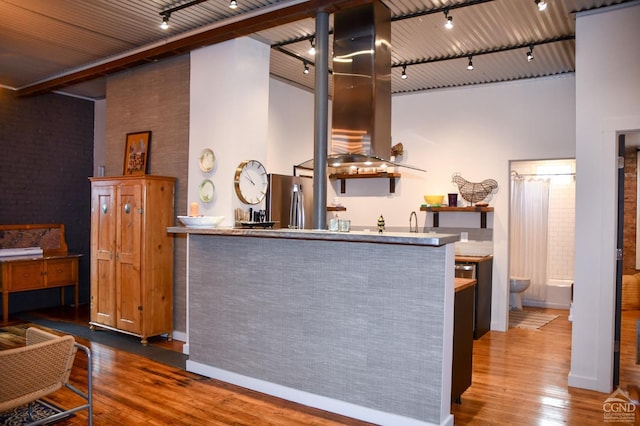 17-23 Linden St, Pittsfield, MA 01201 - bar with wood finished floors, freestanding refrigerator, a high ceiling, island exhaust hood, and track lighting