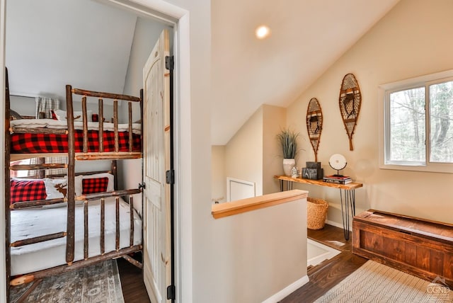 hall with vaulted ceiling, dark wood finished floors, and baseboards