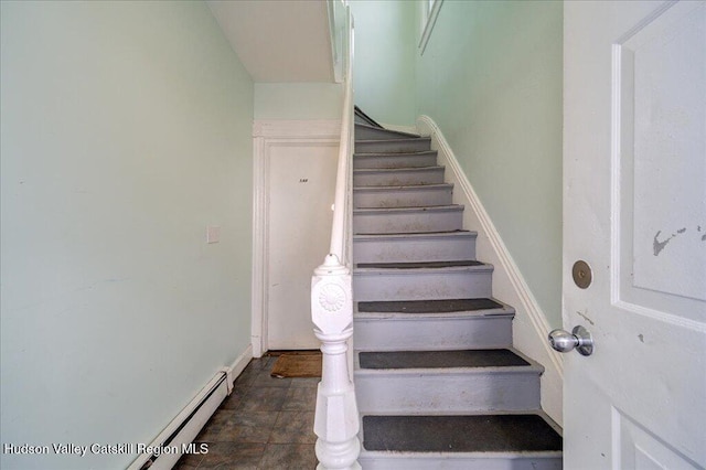 stairs featuring a baseboard heating unit