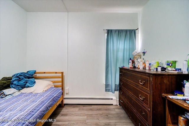 bedroom featuring a baseboard radiator and wood finished floors