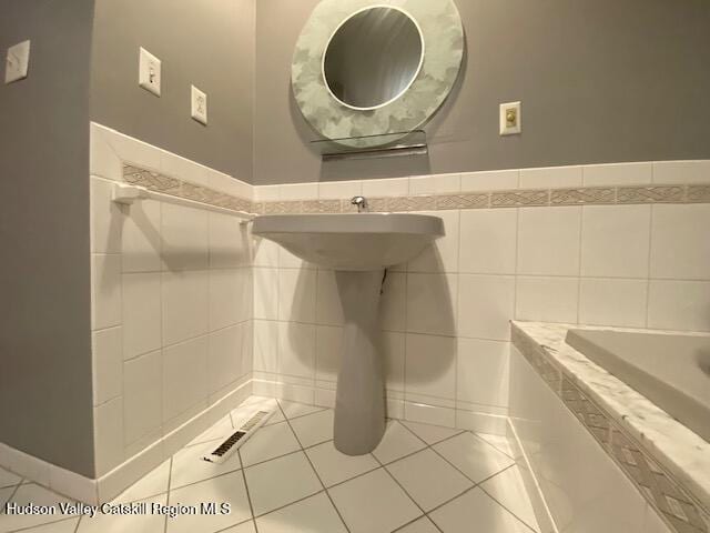 bathroom with tile patterned flooring and tile walls