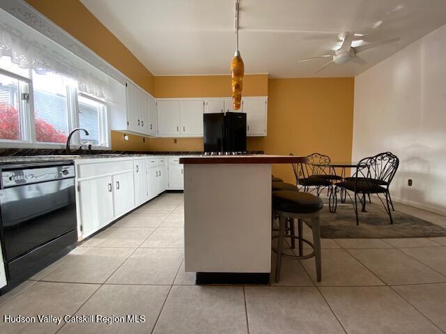 21 Lohmaier Ln, Lake Katrine, NY 12449 - kitchen featuring freestanding refrigerator, dishwasher, a kitchen island, light tile patterned flooring, and white cabinets