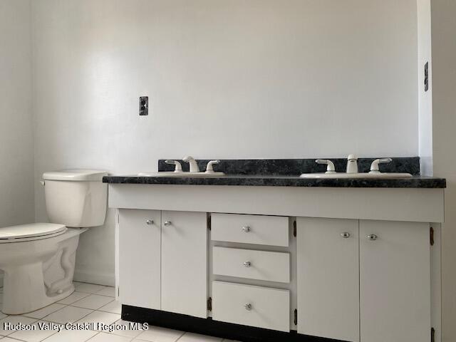 bathroom with tile patterned flooring, vanity, and toilet