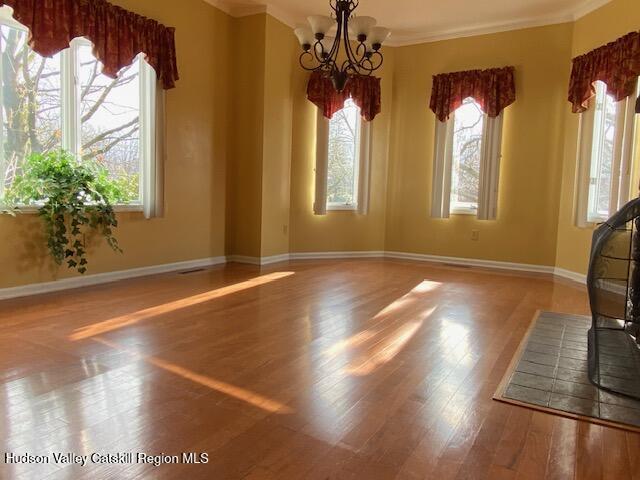 21 Lohmaier Ln, Lake Katrine, NY 12449 - unfurnished dining area with a chandelier, plenty of natural light, wood finished floors, and crown molding