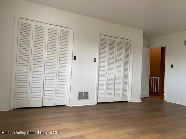 21 Lohmaier Ln, Lake Katrine, NY 12449 - unfurnished bedroom featuring two closets and wood finished floors