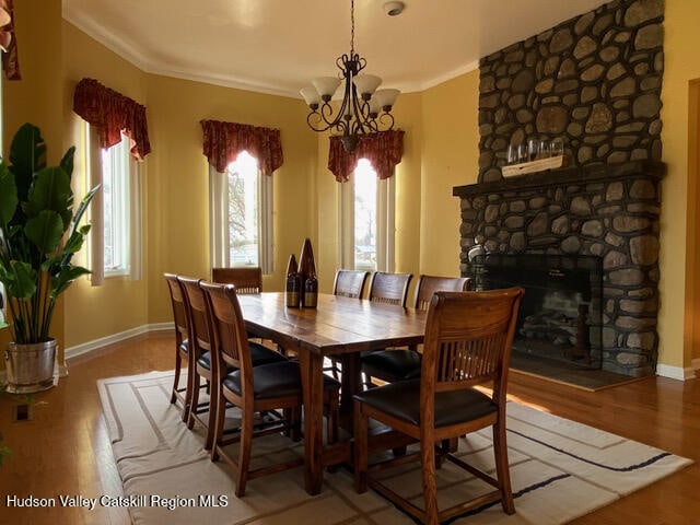 21 Lohmaier Ln, Lake Katrine, NY 12449 - dining space with wood finished floors, a chandelier, a fireplace, and crown molding