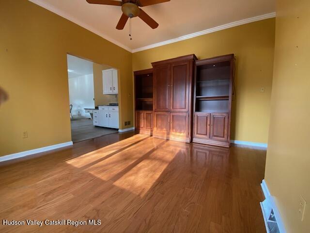 interior space with ceiling fan, dark hardwood / wood-style flooring, and ornamental molding