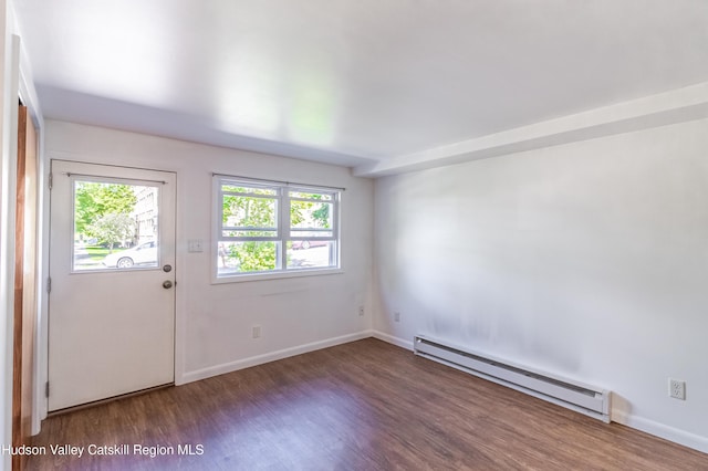 interior space with baseboards, baseboard heating, and wood finished floors