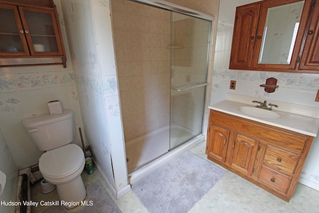 bathroom featuring tile patterned floors, vanity, toilet, and walk in shower