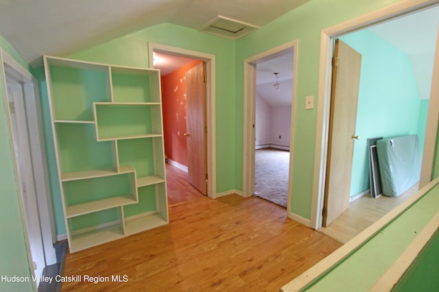 hall with baseboard heating, wood-type flooring, and lofted ceiling