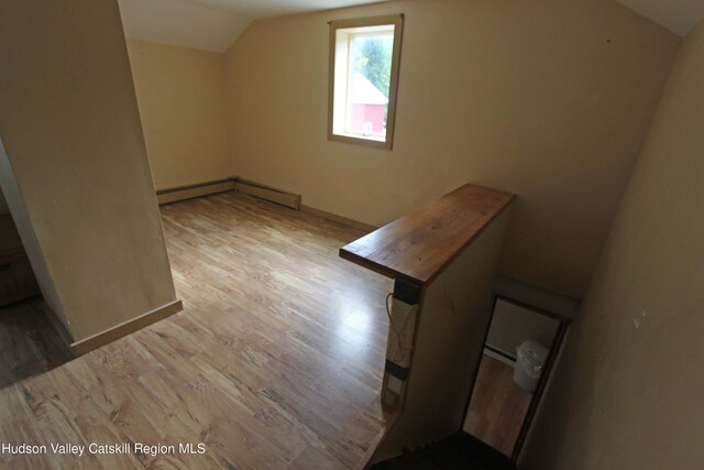 bonus room with light hardwood / wood-style floors, baseboard heating, and lofted ceiling