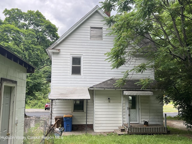 rear view of house featuring fence