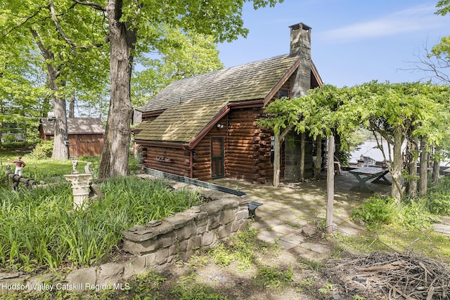 277 Patterson Ln, West Camp, NY 12490 - back of property featuring log siding, a patio, a chimney, and an outdoor structure