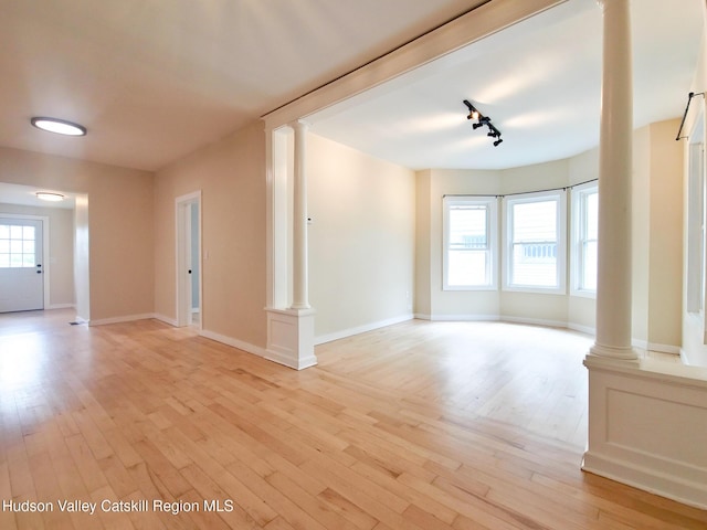 40 Fairview Ave, Hudson, NY 12534 - unfurnished living room featuring ornate columns, light wood-style flooring, and rail lighting