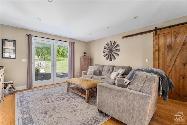  - living room with a barn door, light wood finished floors, baseboards, and recessed lighting