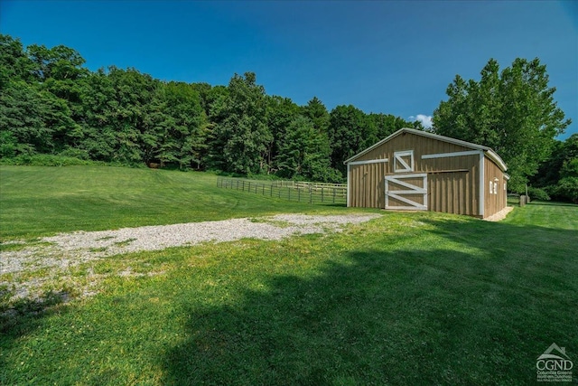  - view of yard featuring an outdoor structure and a wooded view