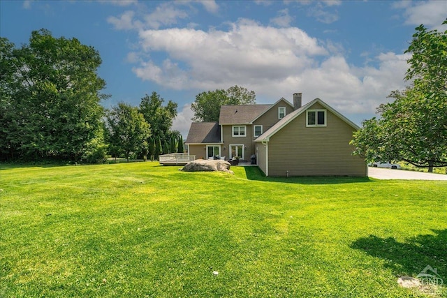  - back of property featuring a lawn, a deck, and a chimney