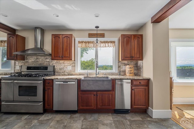  - kitchen with wall chimney exhaust hood, stainless steel appliances, a sink, tasteful backsplash, and healthy amount of natural light