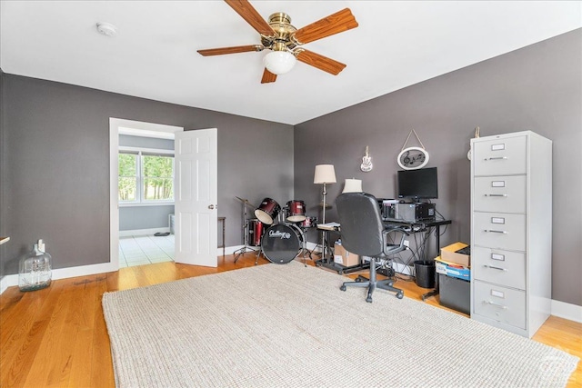  - office area with a ceiling fan, baseboards, and wood finished floors