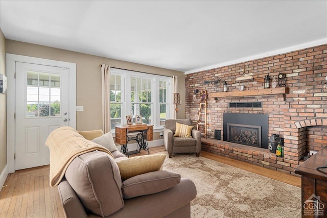  - living room with healthy amount of natural light, hardwood / wood-style floors, a brick fireplace, and baseboards