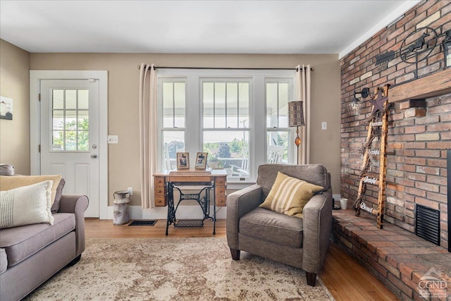  - living area featuring wood finished floors and brick wall