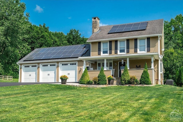 - view of front of house with a porch, roof mounted solar panels, a front lawn, and cooling unit