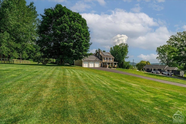  - view of yard featuring driveway and a garage