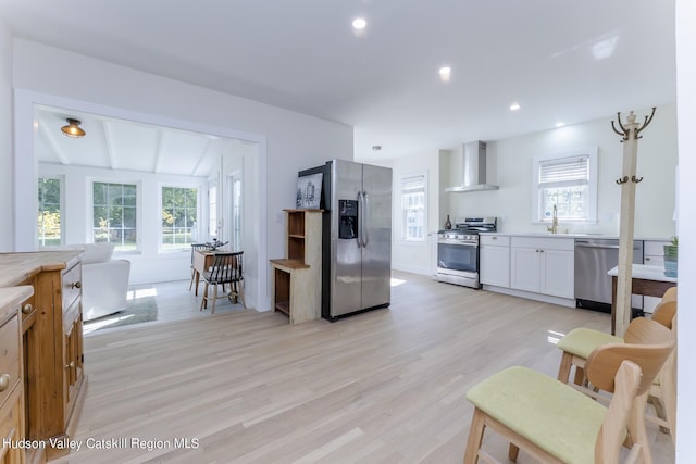 179 Grove St, Tillson, NY 12486 - kitchen with appliances with stainless steel finishes, wall chimney range hood, light wood finished floors, white cabinetry, and light countertops