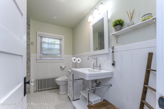 bathroom with radiator heating unit, toilet, and sink