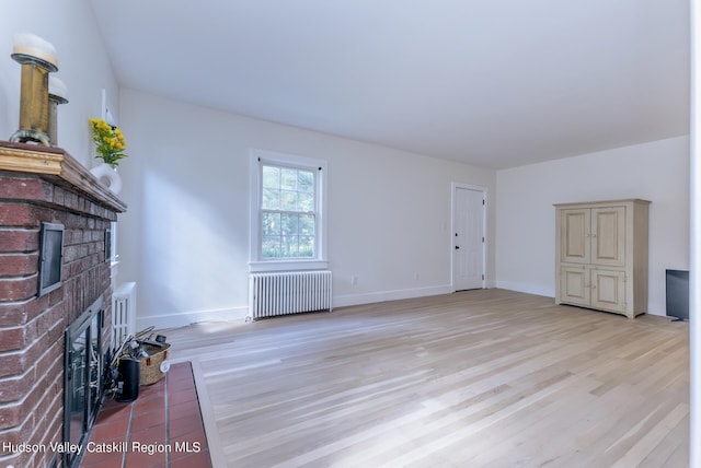 179 Grove St, Tillson, NY 12486 - unfurnished living room featuring radiator heating unit, a fireplace, light wood-style flooring, and baseboards