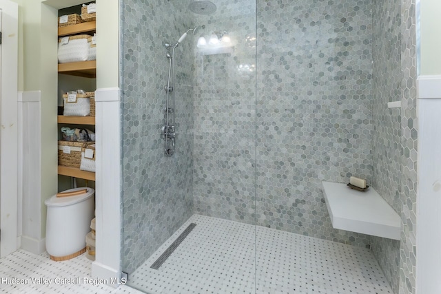 bathroom with tile patterned flooring and a tile shower