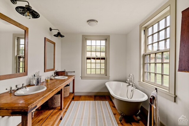 118 Finkle Rd, Ancram, NY 12503 - bathroom with wood finished floors, a soaking tub, baseboards, and double vanity