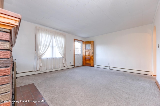 spare room featuring carpet and a baseboard radiator