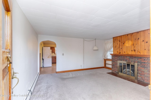 unfurnished living room with a fireplace, light colored carpet, and a baseboard heating unit