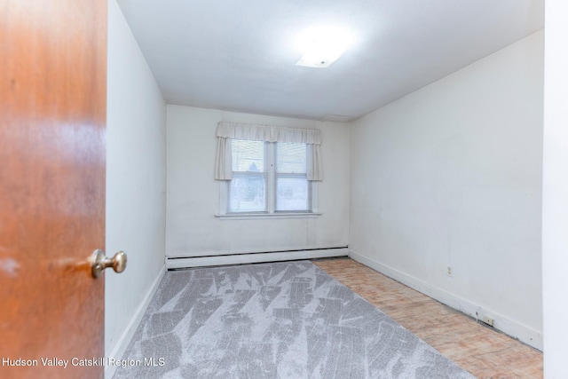 carpeted spare room featuring a baseboard heating unit