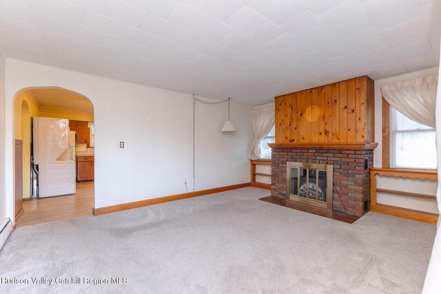 unfurnished living room featuring a fireplace and light colored carpet