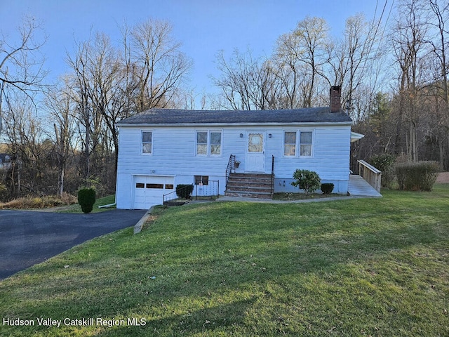 raised ranch featuring a garage and a front lawn