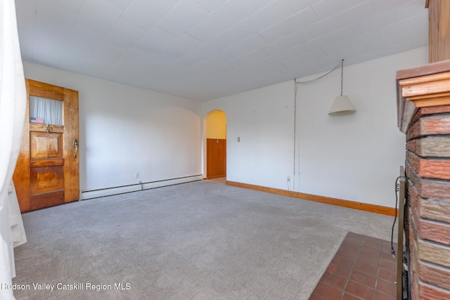 empty room with dark colored carpet and a baseboard radiator