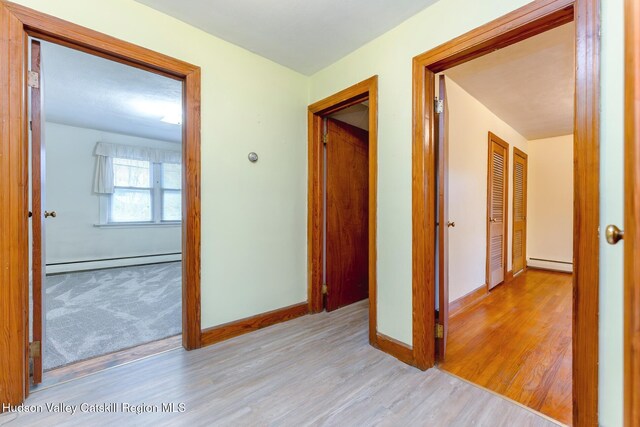 hallway featuring light hardwood / wood-style flooring and a baseboard heating unit