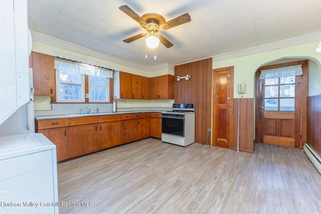 kitchen featuring crown molding, ceiling fan, light hardwood / wood-style floors, white range oven, and washer / clothes dryer