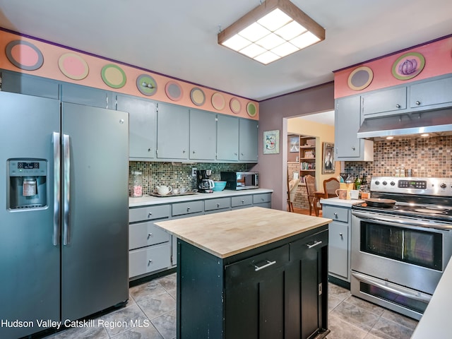 kitchen with tasteful backsplash, a center island, light tile patterned floors, and stainless steel appliances