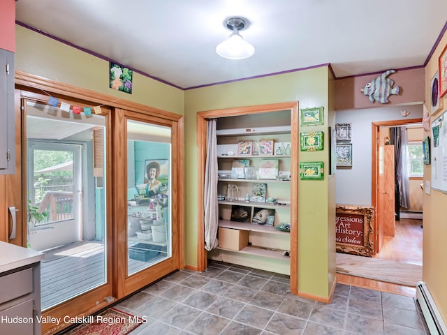 doorway featuring hardwood / wood-style floors, a baseboard radiator, and ornamental molding