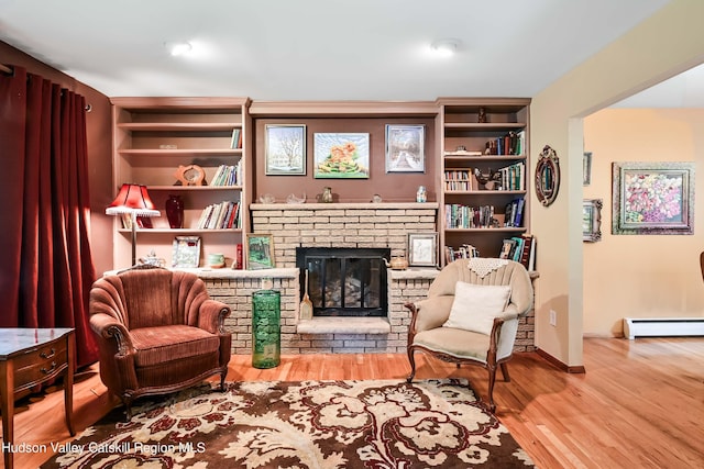 living area featuring a fireplace, hardwood / wood-style floors, and a baseboard radiator