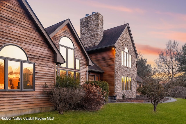 property exterior at dusk featuring a yard