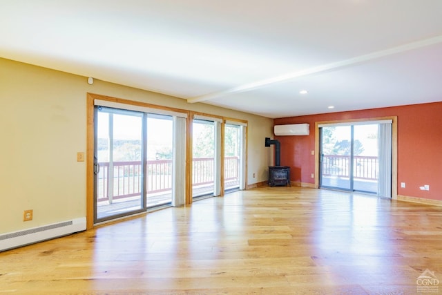 38 Cheviot Rd Unit 8, Germantown, NY 12526 - unfurnished living room with a wood stove, a wall unit AC, healthy amount of natural light, light wood-style flooring, and recessed lighting