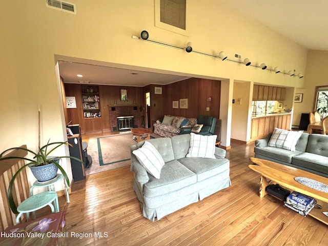 258 Watson Hollow Rd, West Shokan, NY 12494 - living room with hardwood / wood-style floors, a fireplace, high vaulted ceiling, and wooden walls