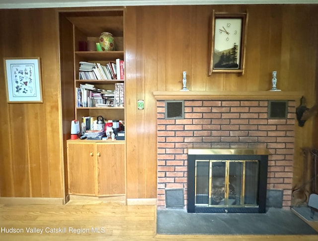 258 Watson Hollow Rd, West Shokan, NY 12494 - detailed view of a brick fireplace, wooden walls, built in features, and wood finished floors
