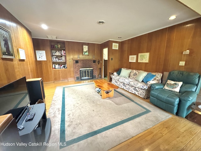 258 Watson Hollow Rd, West Shokan, NY 12494 - living area featuring wood finished floors, wooden walls, a brick fireplace, and ornamental molding