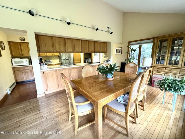 258 Watson Hollow Rd, West Shokan, NY 12494 - dining space featuring a baseboard heating unit, high vaulted ceiling, and wood finished floors