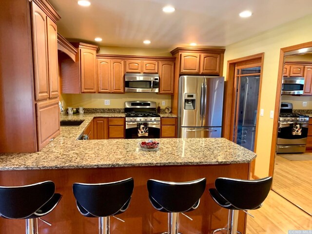 160 Willowbrook Rd, Hudson, NY 12534 - kitchen featuring appliances with stainless steel finishes, a peninsula, a sink, a kitchen bar, and recessed lighting